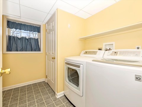 A small kitchen with a white oven and a window with curtains.