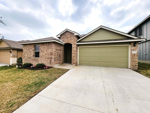 A house with a garage door and a driveway.