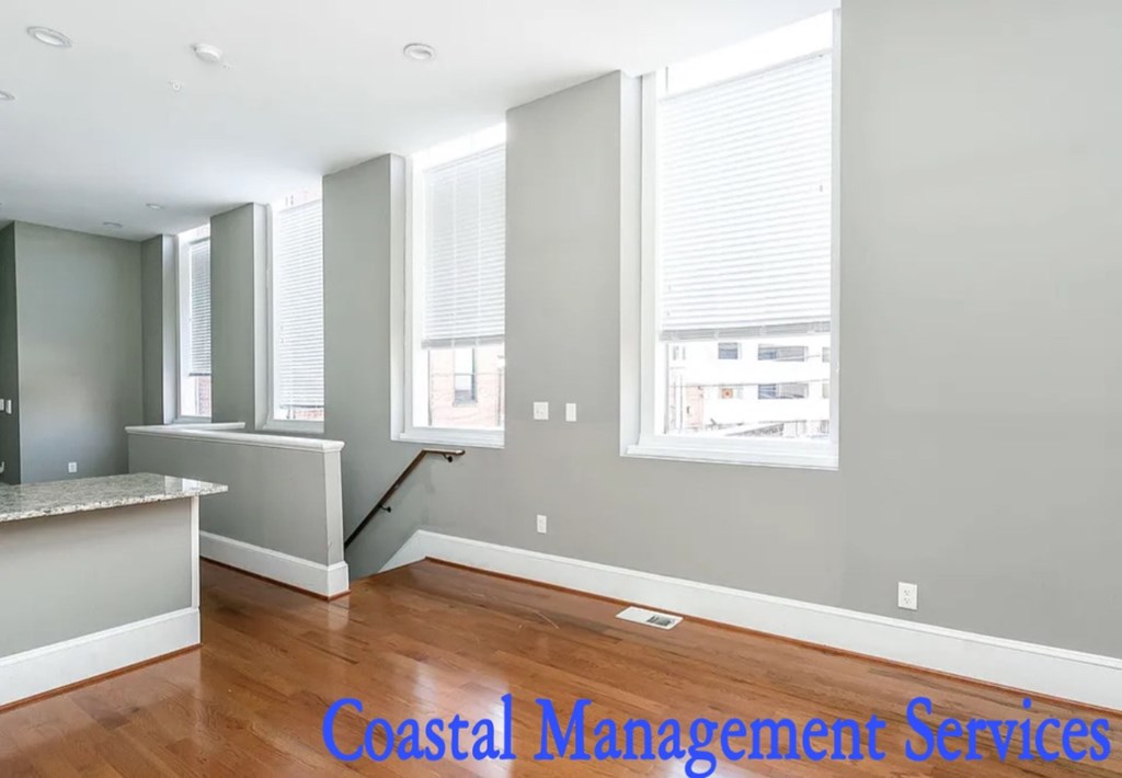 A room with a counter and a window with blinds.