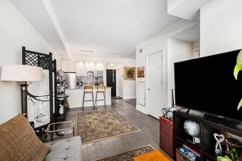 A living room with a grey couch and a brown pillow.