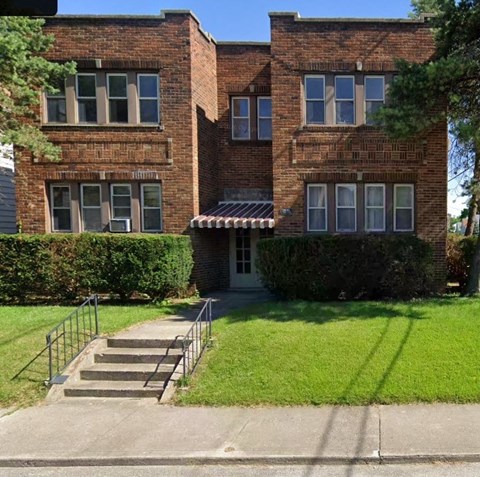 A brick building with a white door and windows.