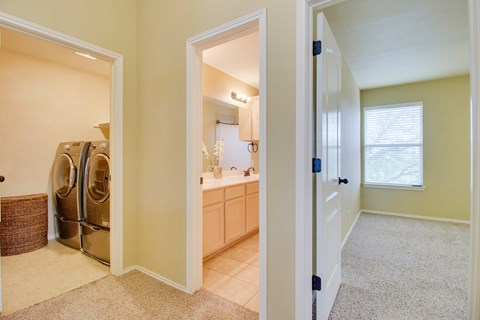 A kitchen with a refrigerator and a sink is visible through an open door.