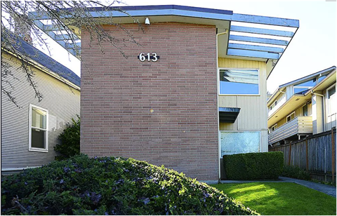 A house numbered 613 with a green bush in front.
