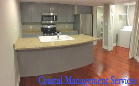 A kitchen with a countertop and a sink is shown with the words Coastal Management Services.