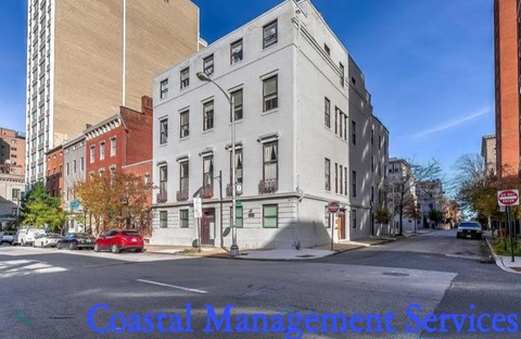 A street view with a building on the right and a sign that says Coastal Management Services.