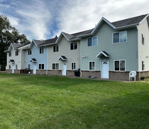 A row of houses with green lawns in front.