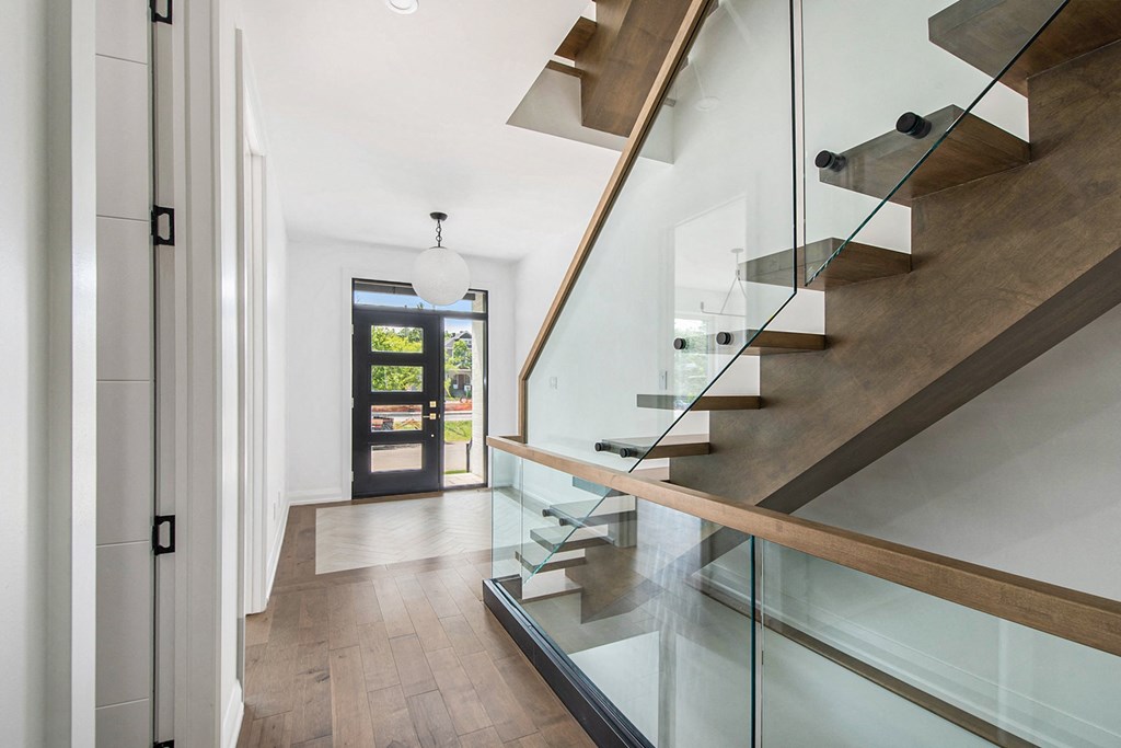 A modern staircase with glass railings and wooden steps.