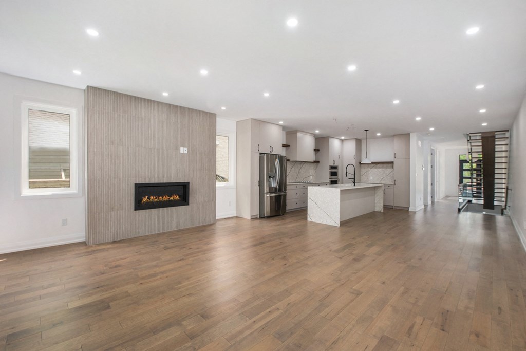 A modern living room with a fireplace and wooden floors.