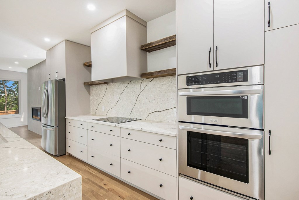 A modern kitchen with stainless steel appliances and white cabinets.