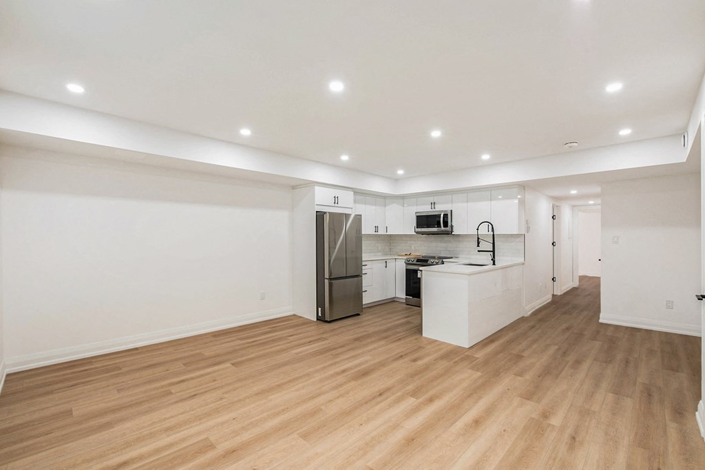 A kitchen with white cabinets and a refrigerator.