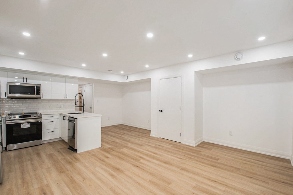 A kitchen with wooden floors and white walls.