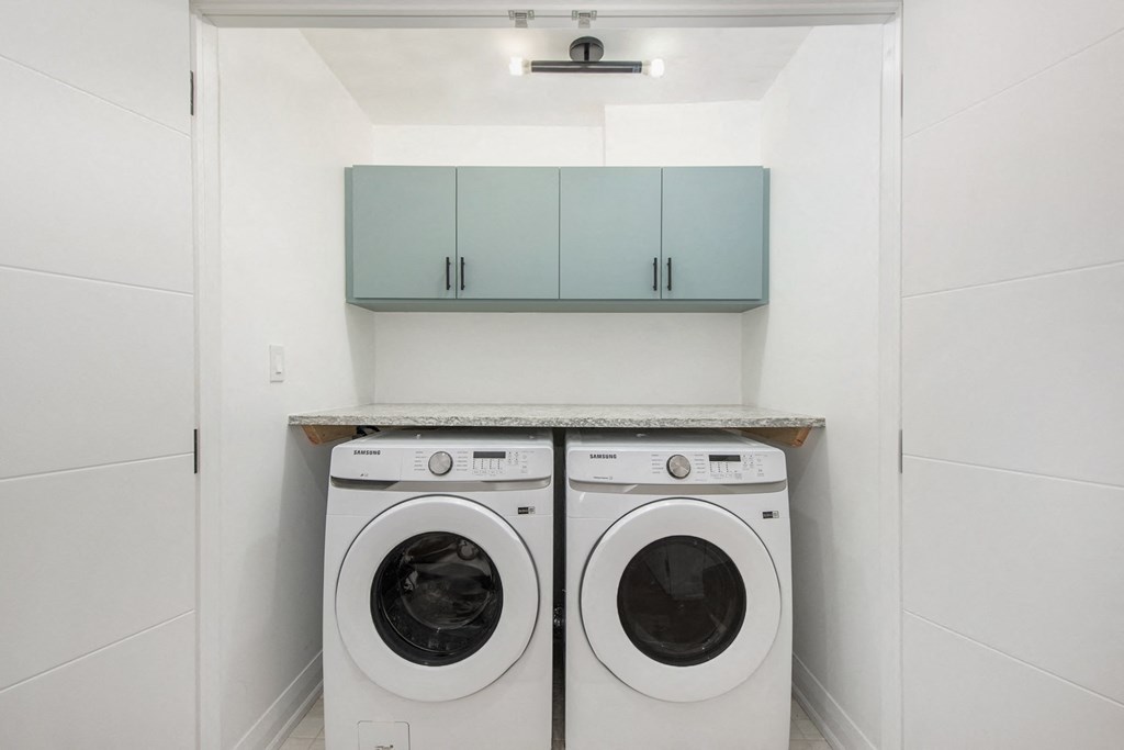 Two washing machines in a small laundry room.