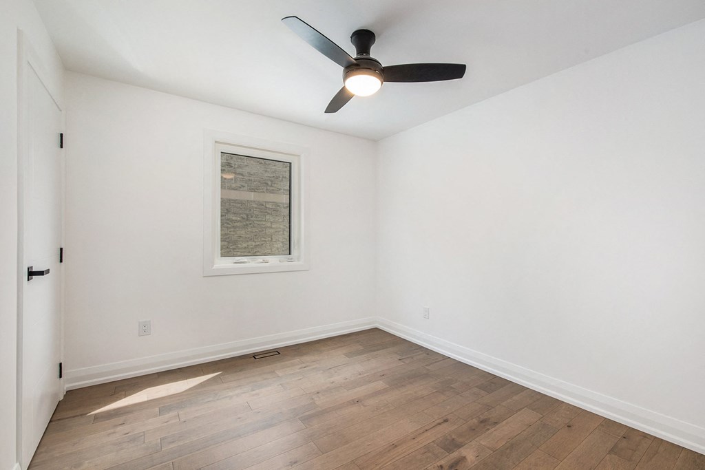A room with a ceiling fan and a picture on the wall.