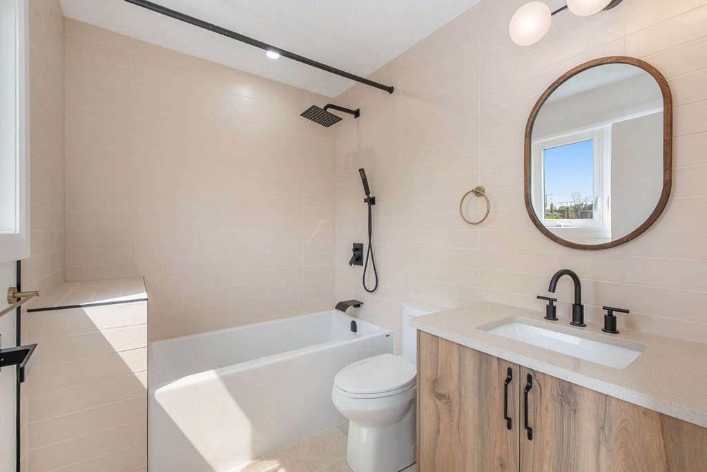 A bathroom with a white tub, sink, and toilet.
