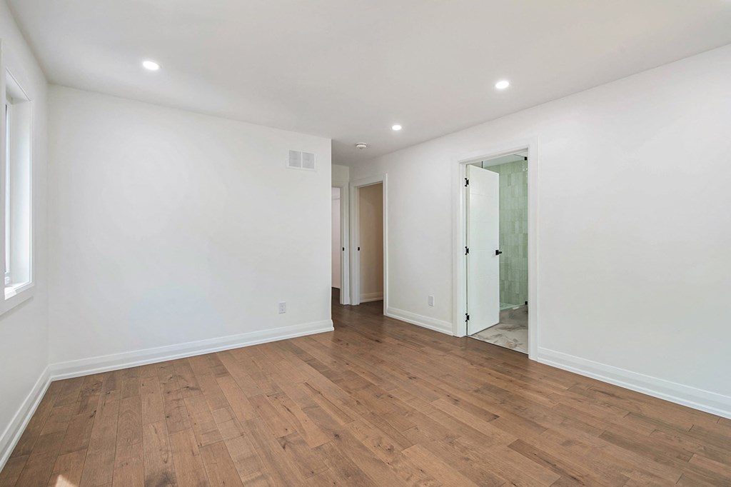 A room with wooden flooring and white walls.