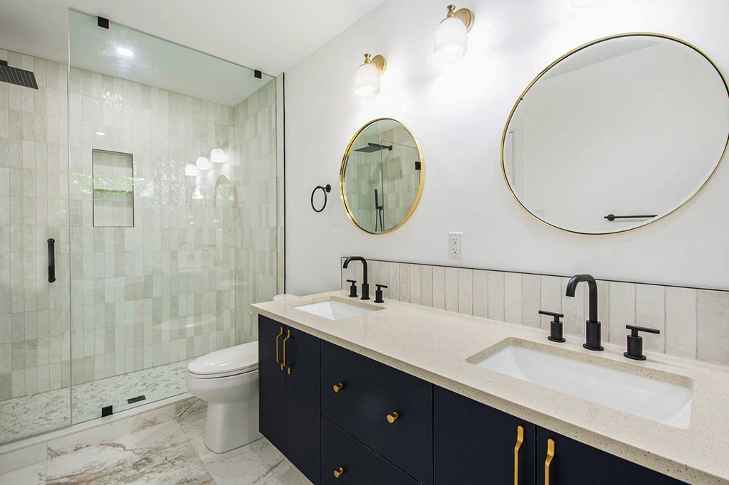 A bathroom with a sink, toilet, and mirror.