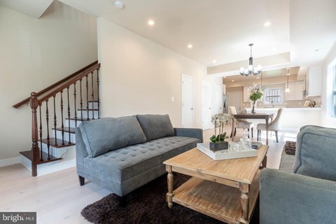 A living room with a grey couch and a wooden coffee table.