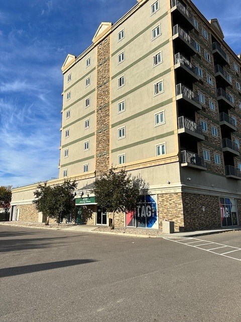 A tall building with a parking lot in front of it.