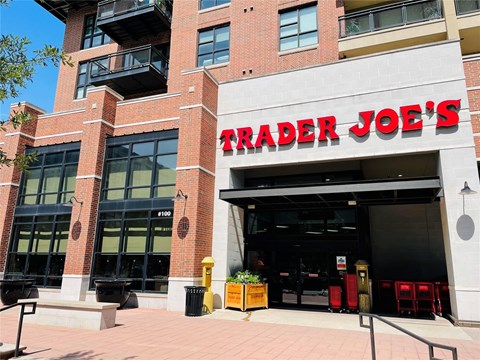 A Trader Joe's storefront with a red brick building and a black awning.