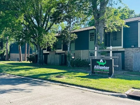 A sign for Alligator in front of a house.