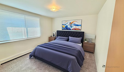 A bedroom with a large bed and a painting on the wall.