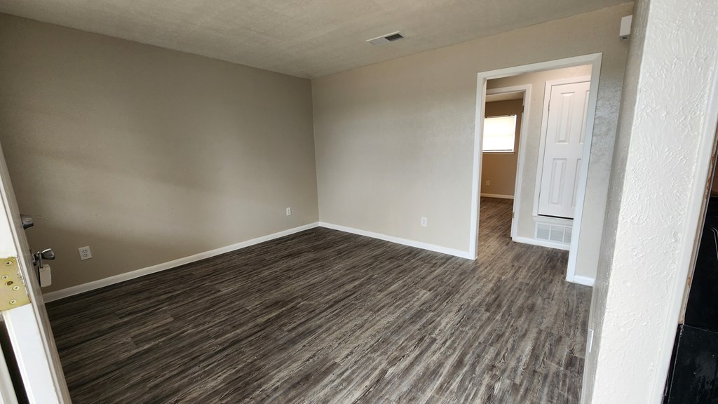 A room with wooden flooring and a white door.