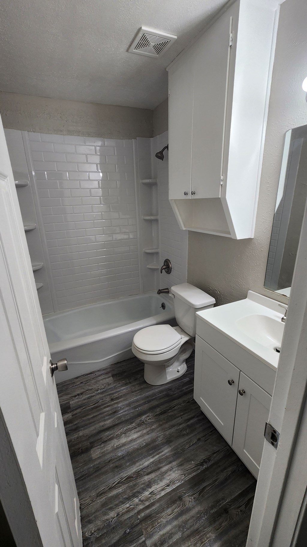 A white bathroom with a toilet, sink, and shower.