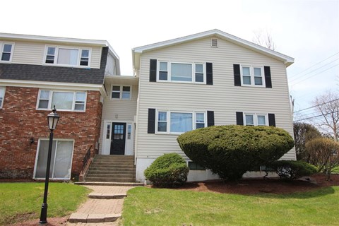 A house with a black door and a small front yard.