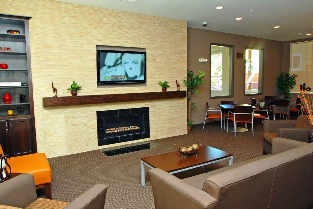 A living room with a fireplace and a television on the wall.