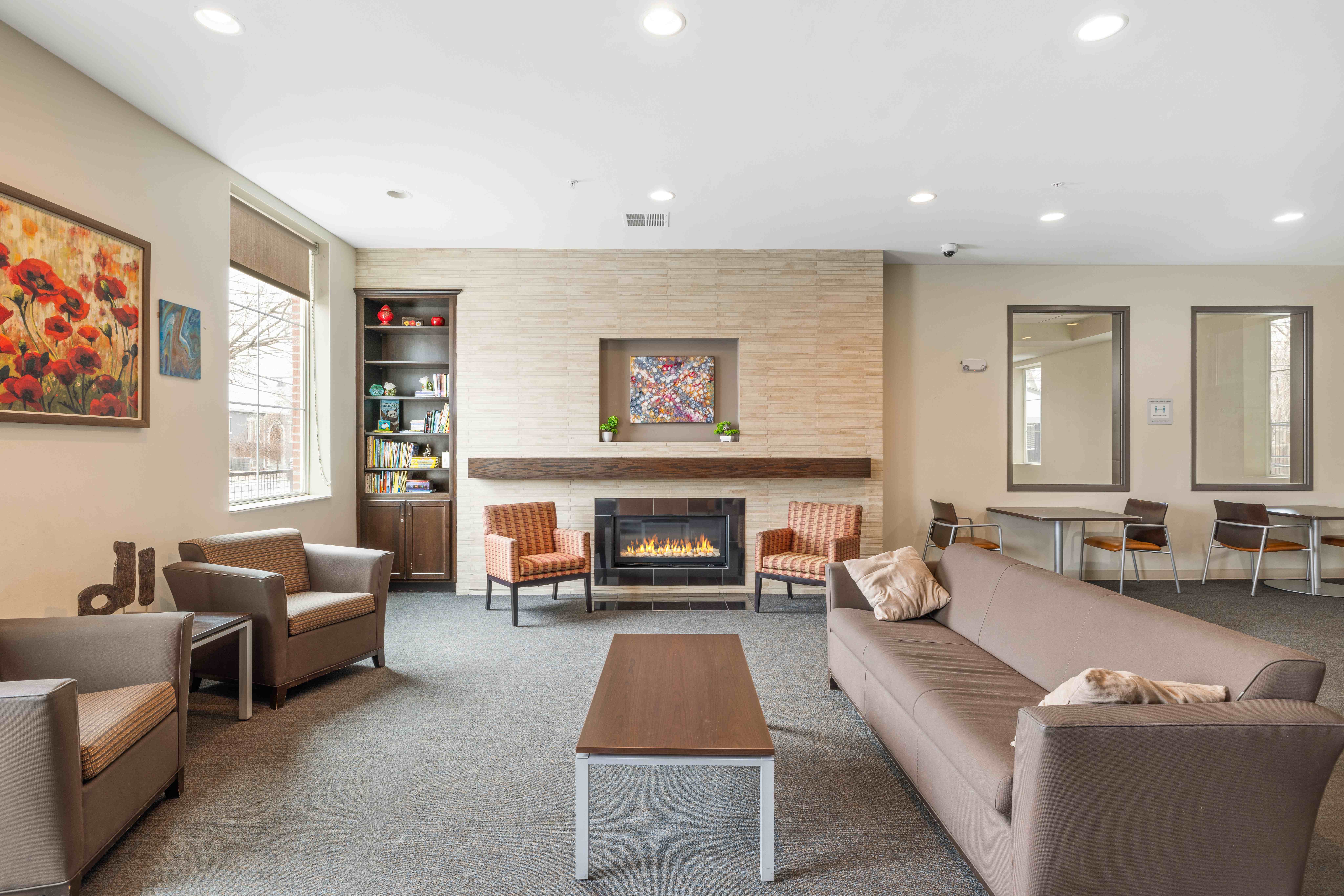 A living room with a fireplace and a painting on the wall.