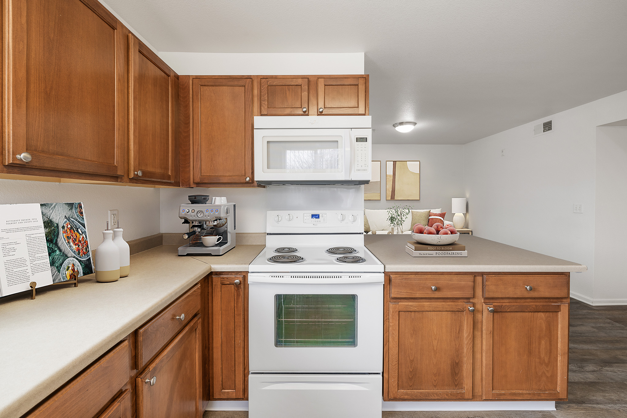 A kitchen with a white stove top oven and a white microwave above it.
