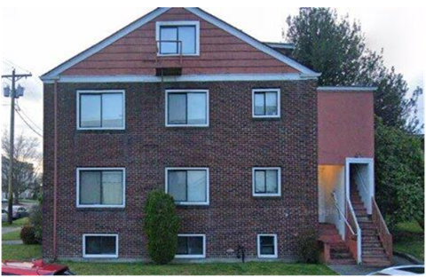 A red brick house with a white door and windows.