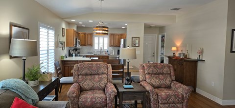 Two floral patterned chairs are in the middle of a living room.