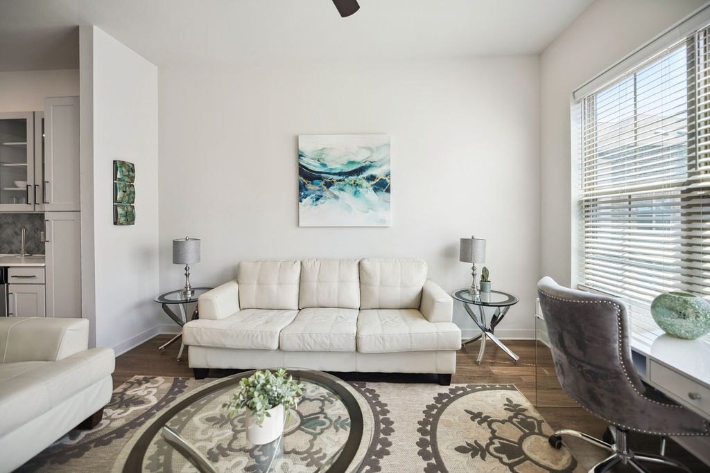 A living room with a white couch and a rug.