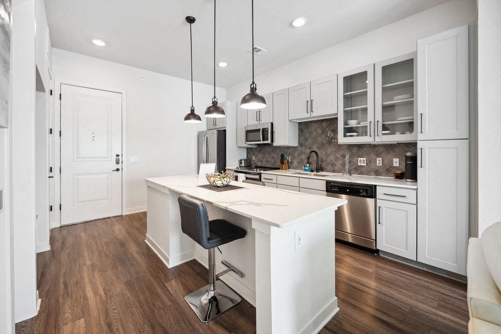 A modern kitchen with white cabinets and a center island.