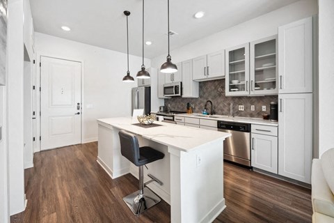 A modern kitchen with white cabinets and a center island.