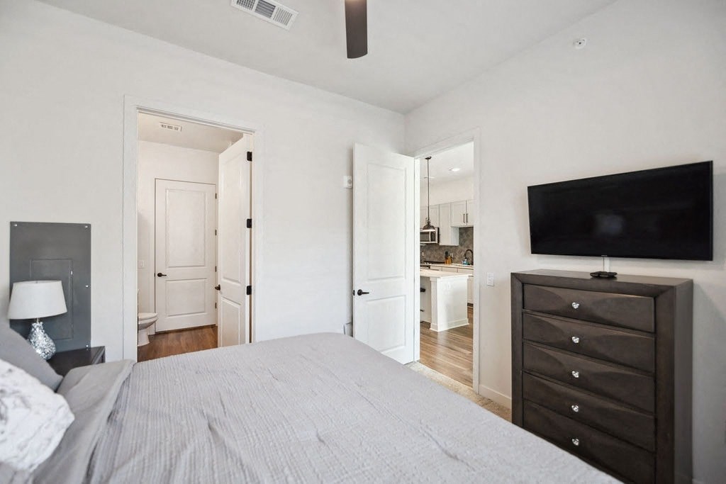 A bedroom with a bed, dresser, and television.