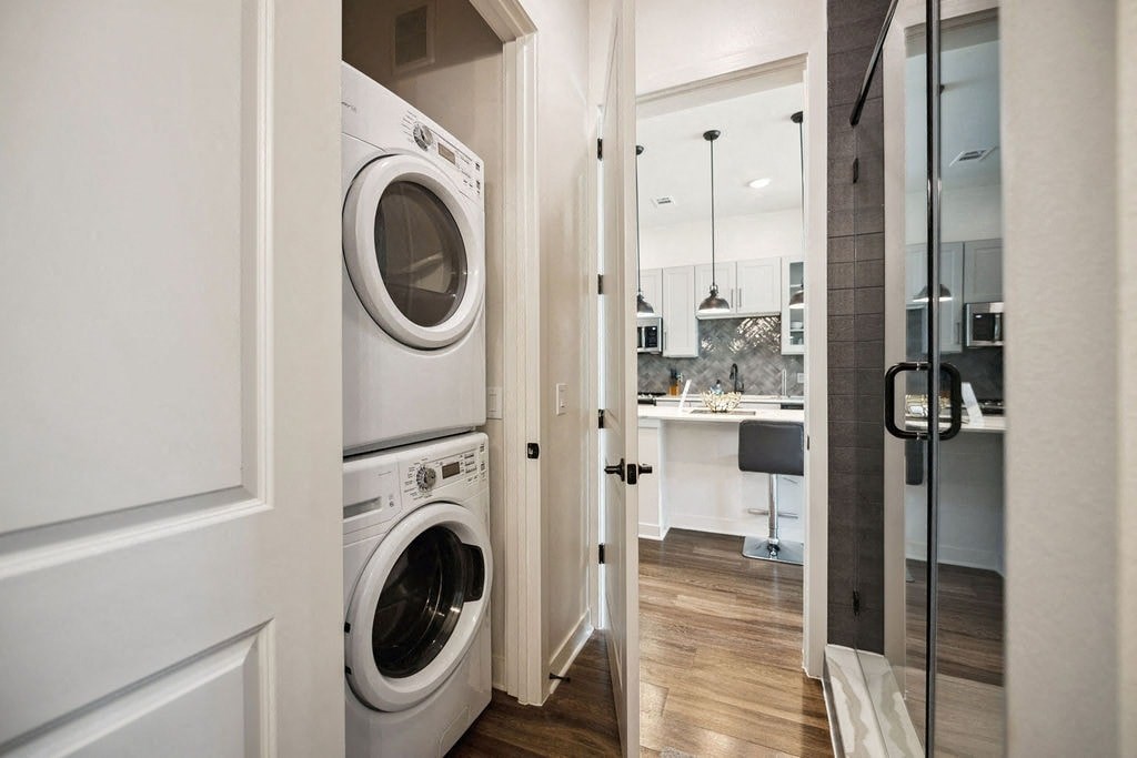 A white washing machine is in a small laundry room.