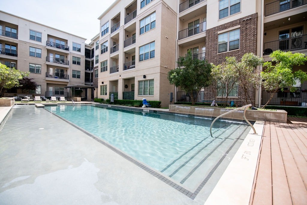 A large swimming pool in front of apartment buildings.