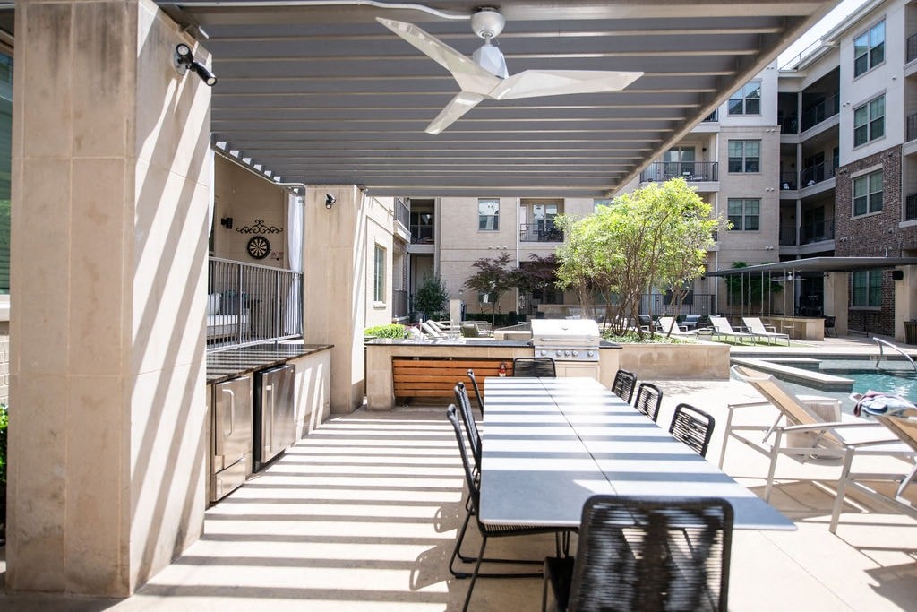 A patio with a table and chairs is covered by a roof.