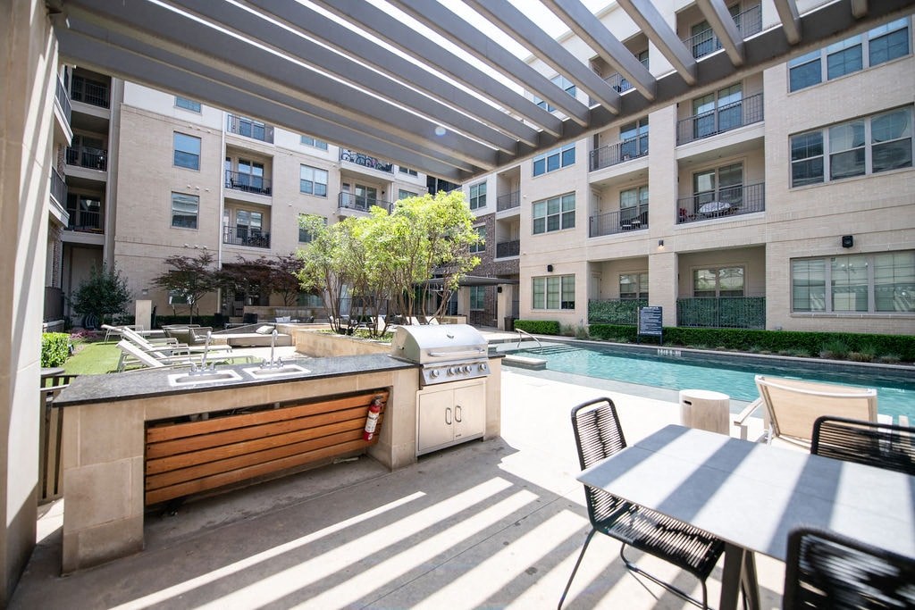 A patio with a table and chairs is surrounded by apartment buildings.
