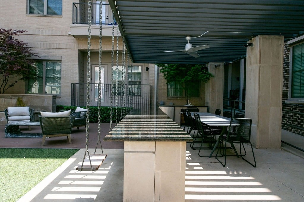 A patio with a table and chairs under a roof.