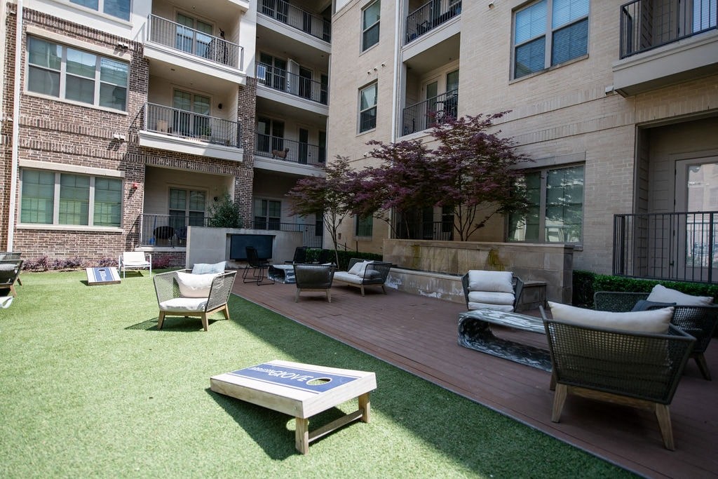 A patio area with a table and chairs is surrounded by apartment buildings.