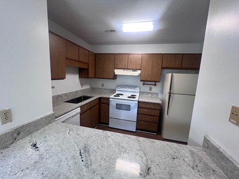A kitchen with a white oven and refrigerator.