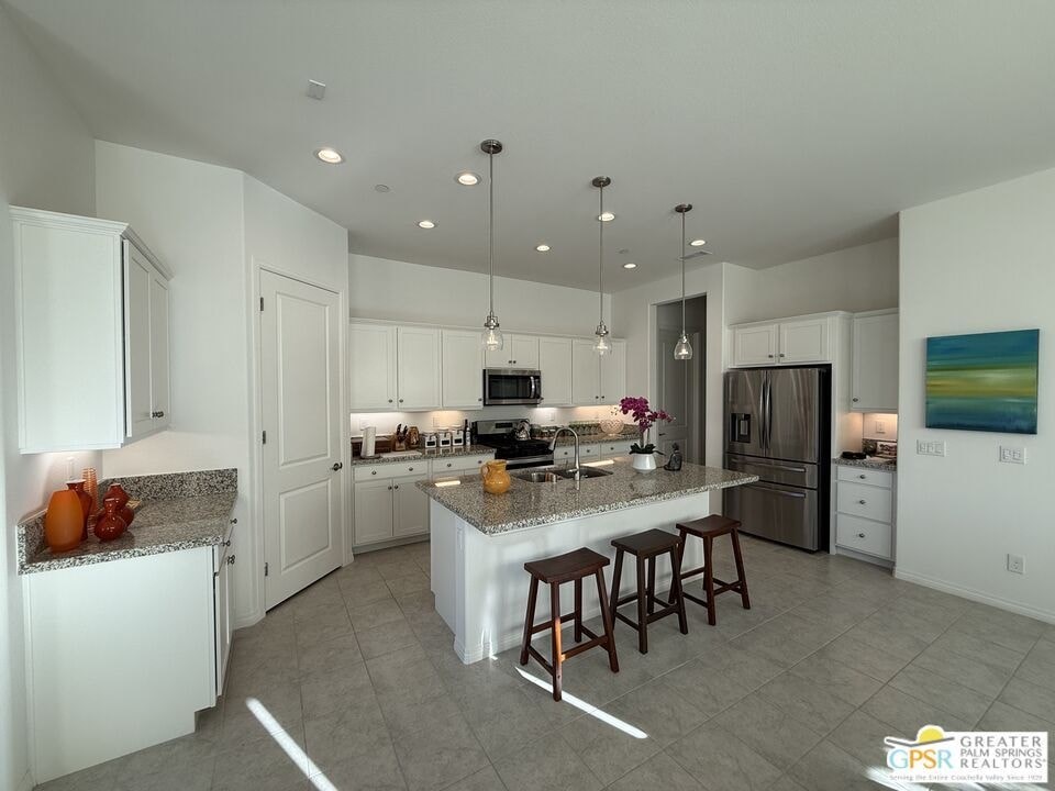 A modern kitchen with white cabinets and a central island.