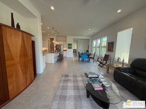 A living room with a black couch, a coffee table, and a wooden cabinet.