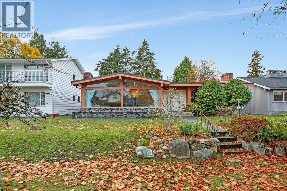 A white house with a gravel pathway leading to the front door.