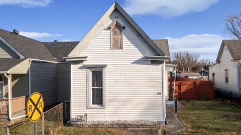 A house with a railroad crossing sign in front of it.