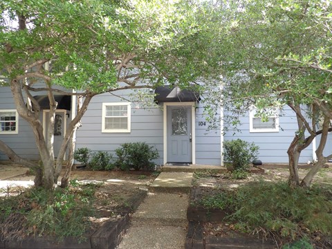 A blue house with a grey door and a small porch.