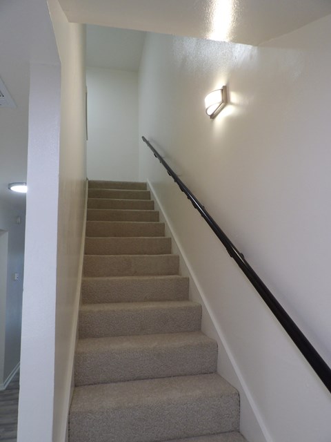 A staircase with a light on the wall.